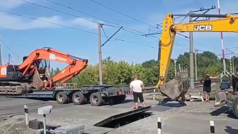 В Саратове экскаватором толкали застрявший на путях тягач 