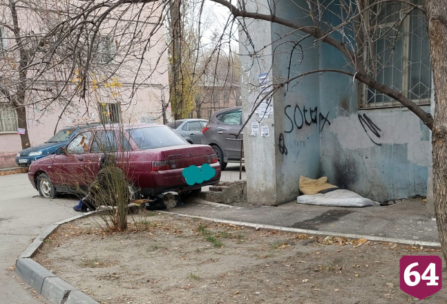 В Саратове женщина спит на улице под балконом 